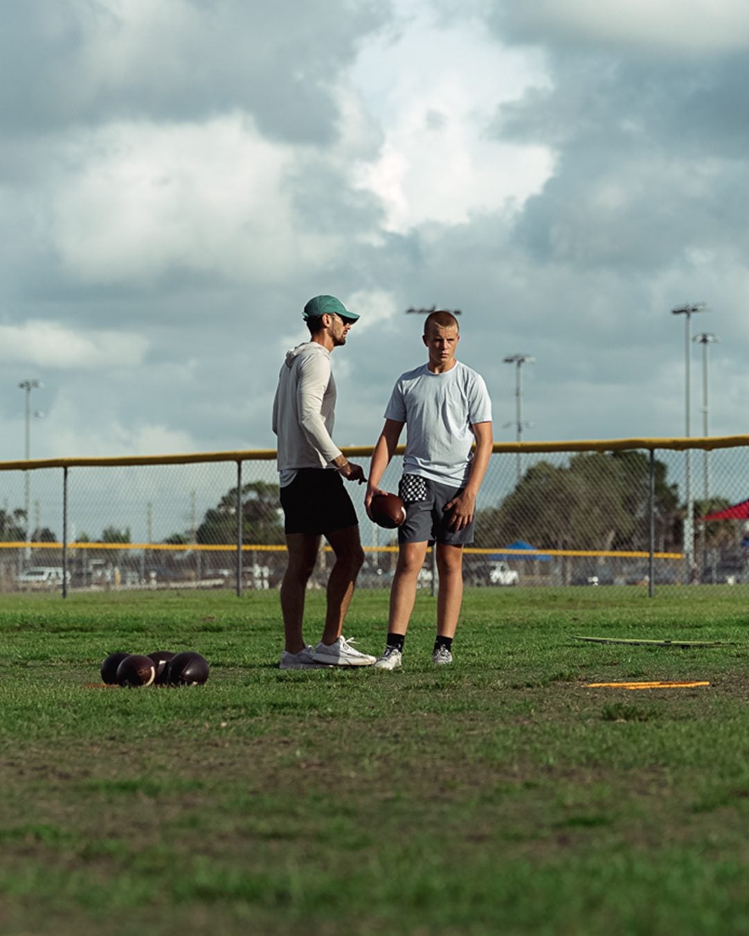 Sage Hansard coaching a quarterback on the practice field